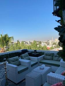 a patio with couches and tables on a balcony at The view II in Amman