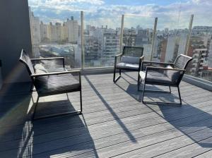 3 sillas en un balcón con vistas a la ciudad en Tu mejor espacio en Palermo en Buenos Aires