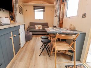 a kitchen and living room with a table and chairs at Hillcrest Shepherds Hut in Preston