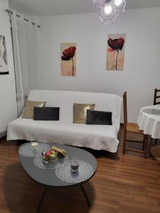 a living room with a white couch and a table at Le Saint Max in Saint-Max