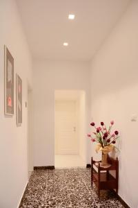 un pasillo con un jarrón de flores sobre una mesa en La Rosa rooms & holiday home, en Porto SantʼElpidio