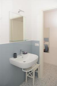 bagno con lavandino bianco e specchio di La Rosa rooms & holiday home a Porto SantʼElpidio