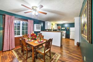 a kitchen and dining room with a table and a ceiling fan at Historic Bruno Hampton Creek Hideaway on 2 Acres in Everton