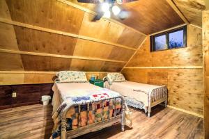 two beds in a room with wooden walls at Historic Bruno Hampton Creek Hideaway on 2 Acres in Everton