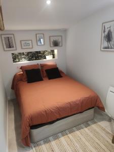 a bedroom with a bed with orange sheets and pillows at Chambre avec entrée indépendante in Esnandes