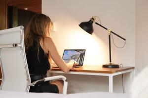 圣塔特蕾莎海滩Outsite Santa Teresa Playa的坐在一张桌子上的手提电脑的女人