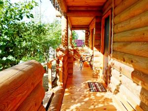 a porch of a log cabin with a window at agrousad'ba Okolitsa in Shchibri