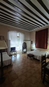 a large room with two beds and a television at Casa Palacio Conde de Garcinarro in Huete