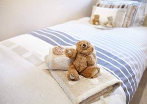 two teddy bears sitting on a bed with towels at Host & Stay - View Point Apartment in Hinderwell