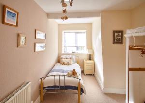 a small bedroom with a bed with a teddy bear on it at Host & Stay - View Point Apartment in Hinderwell