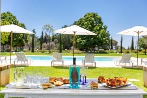 een tafel met eten en drinken naast een zwembad bij Casine Belvedere in Squinzano