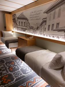 a room with three beds and a mural on the wall at Lipa Hotel in Travnik