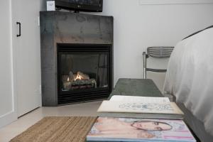 a living room with a fireplace and books on a bench at The Lakeside Motel in Wellington