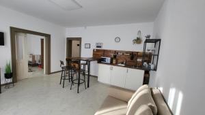 a living room with a couch and a kitchen with a counter at Relax Apartments Sárvár A1 in Sárvár