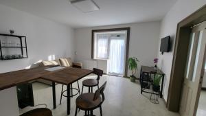 a living room with a wooden table and chairs at Relax Apartments Sárvár A1 in Sárvár