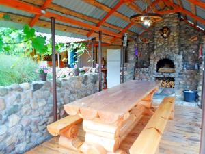 a wooden table on a patio with a stone oven at agrousad'ba Okolitsa in Shchibri