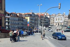 um grupo de pessoas à espera para atravessar uma rua movimentada da cidade em Sé do Porto no Porto