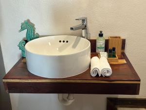 a bathroom sink on a wooden shelf with towels at The Bounty in Caye Caulker