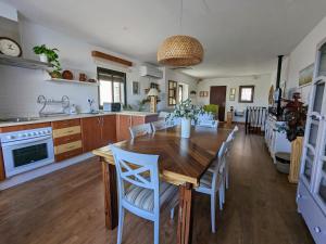 cocina y comedor con mesa de madera y sillas en Casa rural El Olivo, en Aracena