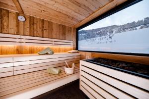 a sauna with wooden walls and a large window at Appartement Viehhauser in Kleinarl