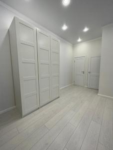 an empty room with white doors and wooden floors at Стильная 2-х комнатная ЖК Браво in Astana