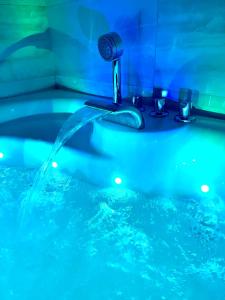 een badkamer met een bad gevuld met blauw water bij Roza Luxury Apartment in Boedapest