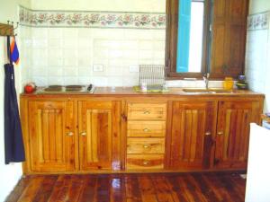 a kitchen with wooden cabinets and a sink at Casa SUPIAVENTO RIO Delta Tigre 8 PREMIUM WIFI in Dique Luján