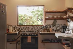 a kitchen with a stove and a window at Outsite Santa Teresa Playa in Santa Teresa Beach