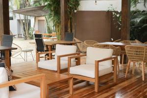 a patio with wooden tables and chairs and tables and tablesktop at Outsite Santa Teresa Playa in Santa Teresa Beach