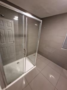 a shower with a glass door in a bathroom at LaLuNa One Bedroom Apartment Newcastle in Elswick