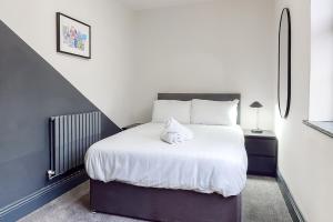 a bedroom with a bed with a white pillow on it at Air Host and Stay - Wright Terrace, 4 bedroom, 2 bathroom sleeps 8 in Liverpool