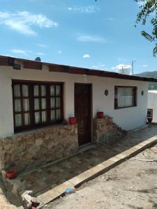 uma casa com uma parede de pedra e uma porta em Casa de montaña em Bialet Massé