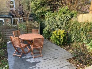 a wooden table and chairs on a wooden deck at Beautiful two bedroom apartment in Honor Oak in London