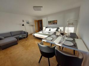 een woonkamer met een bed en een tafel en stoelen bij Chiemsee /Seeblick/ Netflix in Seeon-Seebruck