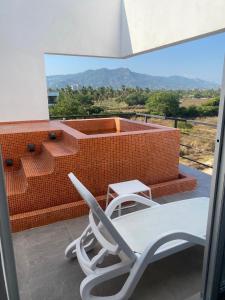 d'une chaise et d'une table sur un balcon. dans l'établissement Papaya Condo Acapulco Diamante -Solo Adultos, à Acapulco