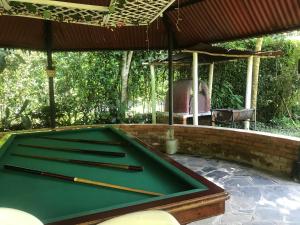 una mesa de billar con dos tacos encima en Casa Quinta privada con piscinas Billar, Tejo, Jacuzzy climatizado, kiosco, en La Vega