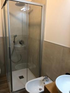 une douche avec une porte en verre à côté d'un lavabo dans l'établissement Paradise Dolomiti flat, à Falcade