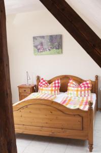 a bedroom with a wooden bed with pillows on it at Heidehof Pension B & B in Elten