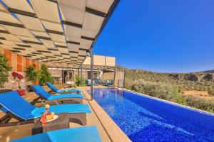 a swimming pool with blue lounge chairs and a swimming pool at Villa Çalıkuşu Kalkan in Kaş