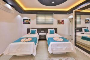 a bedroom with two beds and a mirror at Villa Çalıkuşu Kalkan in Kaş