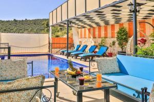 a patio with chairs and a table next to a pool at Villa Çalıkuşu Kalkan in Kaş