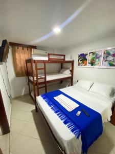 a bedroom with a bed and a bunk bed with a blue blanket at Hotel La Guajira in Ríohacha