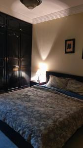 een slaapkamer met een groot bed en een lamp bij Appartement au centre Agadir résidence privée in Agadir