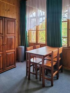 a dining room with a wooden table and chairs at Willa Słoneczko in Szklarska Poręba