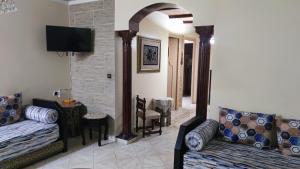 een woonkamer met 2 banken en een spiegel bij Appartement au centre Agadir résidence privée in Agadir