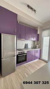 a kitchen with purple cabinets and purple appliances at Sea Sparkle 1a in Preveza