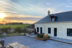 a white house with a sunset in the background at Cocon des vignes du Domaine Ansodelles in Benais