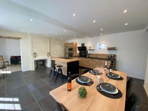 a kitchen and living room with a wooden table and chairs at Cocon des vignes du Domaine Ansodelles in Benais