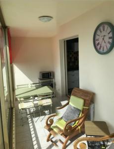a room with a table and chairs and a clock at Charming Studio With Terrace And 180 Sea View in Six-Fours-les-Plages