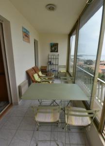 a living room with a table and chairs on a balcony at Charming Studio With Terrace And 180 Sea View in Six-Fours-les-Plages